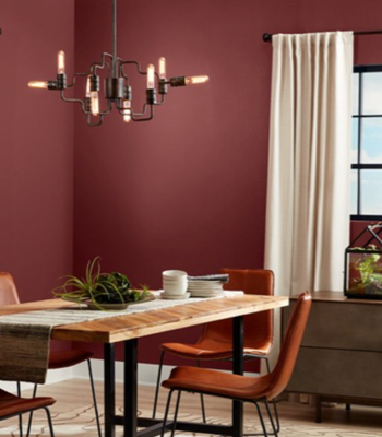 Romantic and modern Red Henna dining room with leather, wood and metal furniture and dark-paned windows.