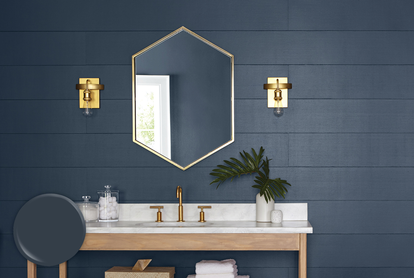 Horizontally paneled bathroom wall in Gotham Gray, with sleek wood and marble vanity featuring gold fixtures. 